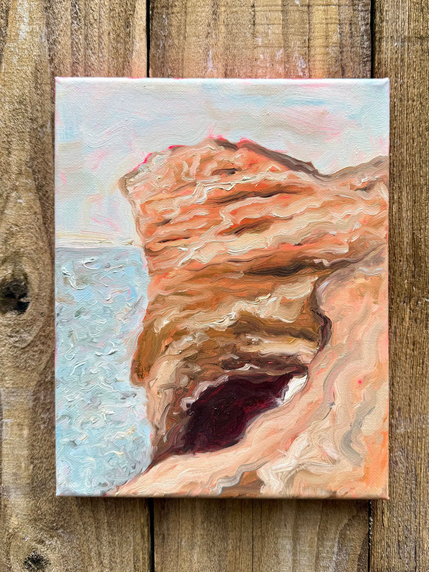 Painting of a natural landscape, an arch on a beach painted on a wooden surface