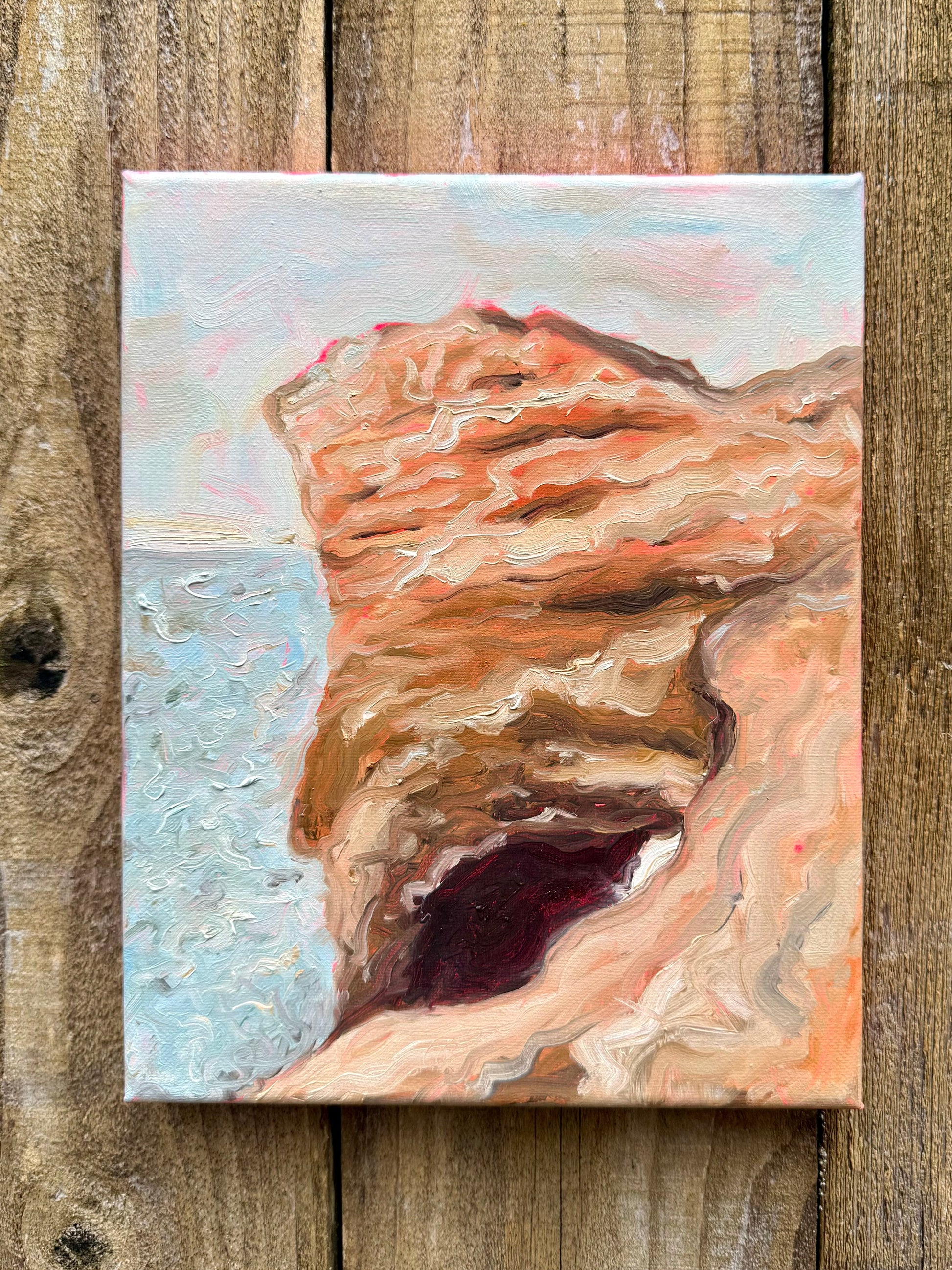 Painting of a natural landscape, an arch on a beach painted on a wooden surface