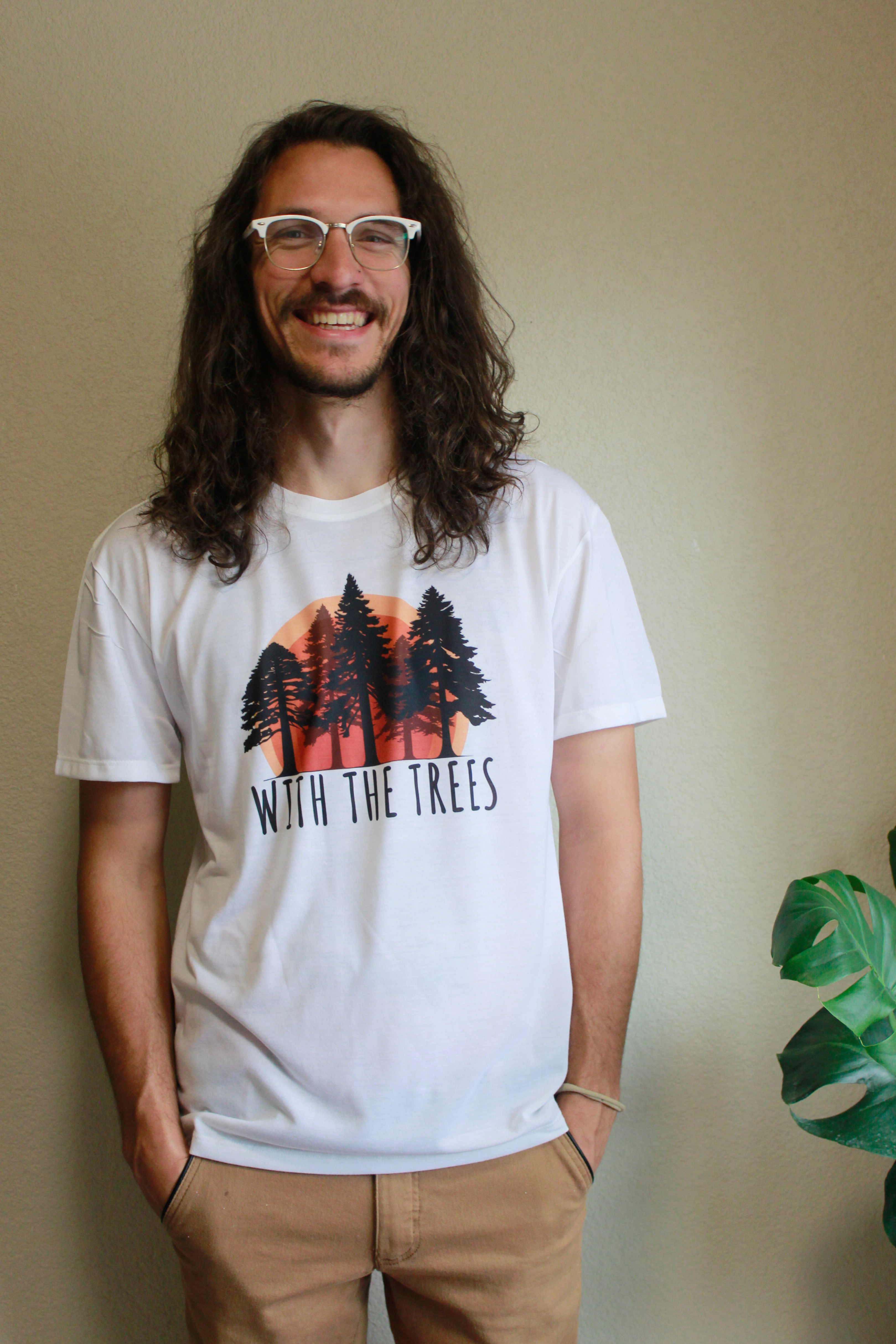 tee design of a sunset and trees with a with the trees logo design in colorful red and orange hues